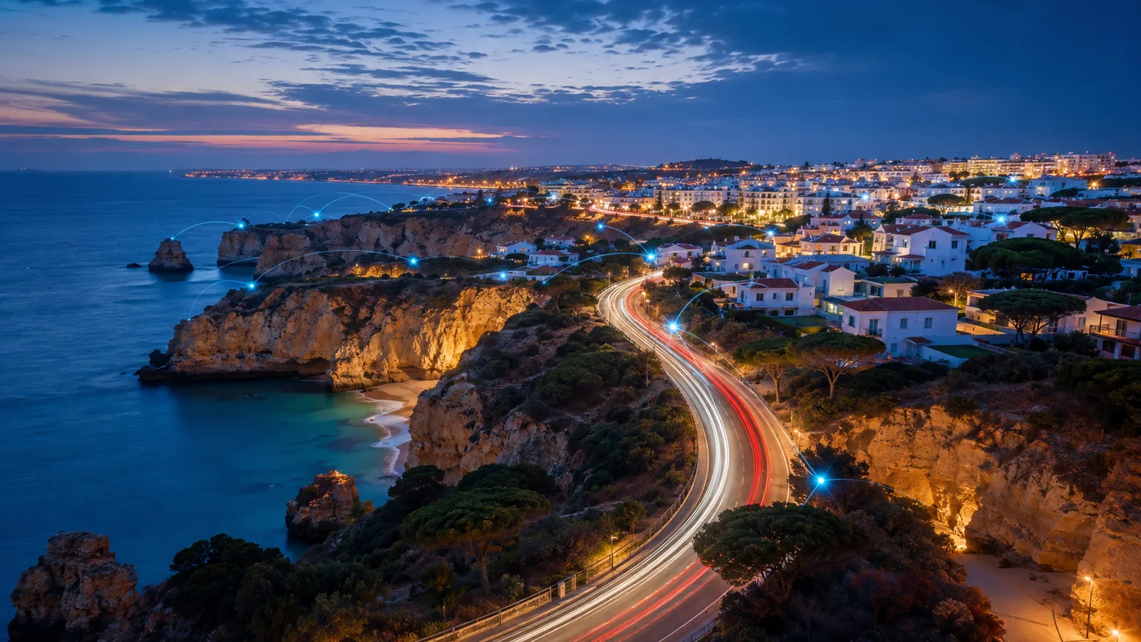 A costa do Algarve ao anoitecer, com os rastos de luz do trânsito na estrada da falésia